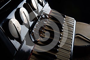 Old accordion, tambourine and triangle on rustic wooden surface with black background and Low key lighting, selective focus photo