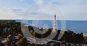 Old active lighthouse. Gloomy sky and cold blue atmosphere. Beach, north misty sea in vintage Scandinavian style