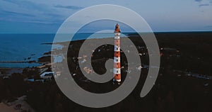 Old active lighthouse. Gloomy sky and cold blue atmosphere. Beach, north misty sea in vintage Scandinavian style