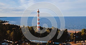 Old active lighthouse. Gloomy sky and cold blue atmosphere. Beach, north misty sea in vintage Scandinavian style