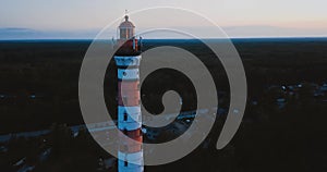 Old active lighthouse. Gloomy sky and cold blue atmosphere. Beach, north misty sea in vintage Scandinavian style