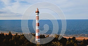 Old active lighthouse. Gloomy sky and cold blue atmosphere. Beach, north misty sea in vintage Scandinavian style