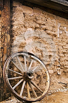 Old Adobe Building and Wooden Wagon Wheel in Tucson Arizona