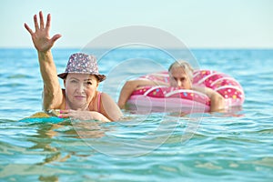 OLD ADULT MAN AND WOMAN SWIM IN THE SEA TOGETHER