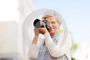 Senior woman photographing by digital camera