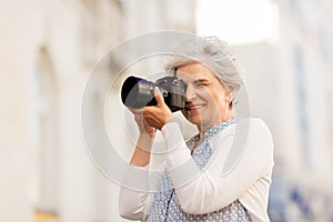 Senior woman photographing by digital camera