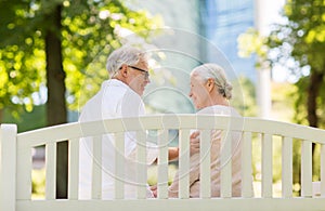 Happy senior couple sitting on bench at park