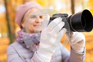 Senior woman with photo camera at autumn park