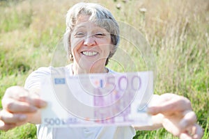 Old age woman holding five hundred euro