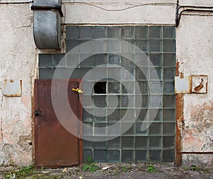 Old aged building fragment, destroyed house. Fragment old closed factory. Old abandoned doors with selective focus. Ruined