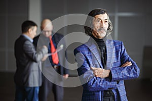 Old aged businessman wearing blue jacket standing