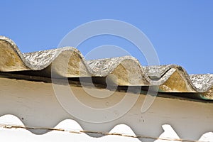 Old aged and damaged dangerous roof made of prefabricated and wave-shaped panels