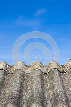 Old aged dangerous roof made of corrugated asbestos panels - one of the most dangerous materials in buildings and construction