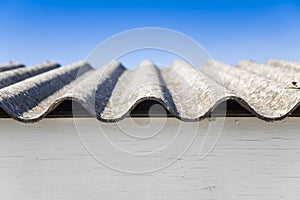 Old aged dangerous roof made of corrugated asbestos panels - one of the most dangerous materials in buildings and construction