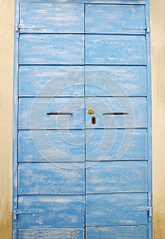 Old and aged historic door in blue wood in the city of San Felice Circeo