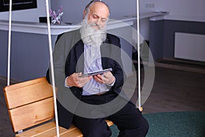 Old aged leader manager use tablet swing in successful company r