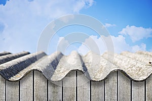 Old aged roof made of corrugated asbestos panels - dangerous materials in buildings and construction industry