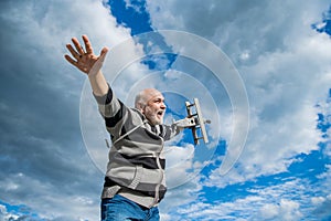old-aged senior man on sky background. senior man at retirement. senior retired man with toy plane