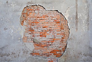 Old and aged wall with flaking plaster and brickwork made of orange brick.