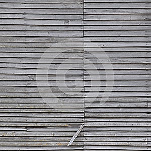 Old weathered natural grey damaged wooden farm shack wall, rustic grungy vertical background closeup, broken boarding pattern