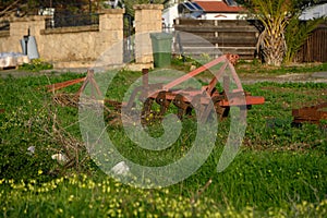 old agricultural machinery lying near a house in the village 1