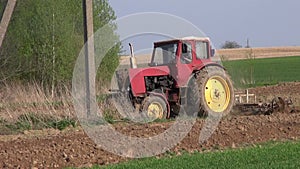 Old agriculture tractor cultivated field in spring