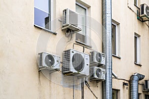 Old air-conditioners hangs on the facade of old building