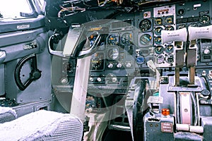 Old aircraft cockpit with yoke and knobs.