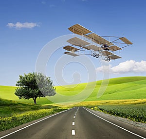 Old aircraft on the green field and road