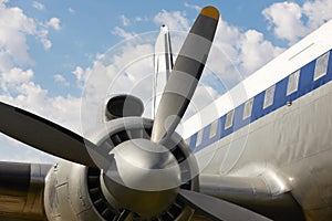 Old aircraft propeller and airframe with blue sky background