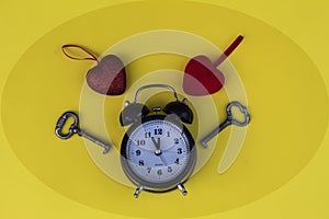 an old alarm clock with bells, two old keys and two hearts