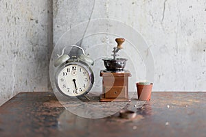 Old alarm clock and coffee grinder and cactus on the iron table