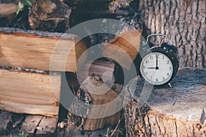 An old alarm clock set at twelve and a star on a rustic wooden surface and firewood