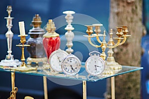 Old alarm clocks and candle holders on flea market in Paris