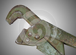 Old alligator wrench on grey background