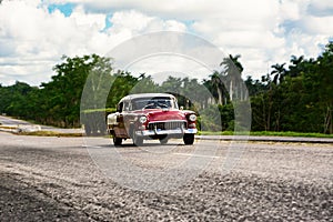 Old american classical car in highway road of Cuba