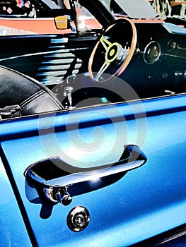 Old American muscle car chrome handle close up and a steering wheel