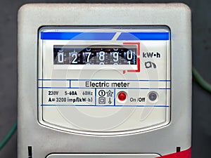 Old analog electric meter on gray background. Electricity consumption