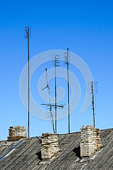 Old analog television antennas of meter and decimeter ranges on the roof with three chimneys