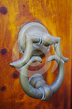 Old ancient door knocker on wooden door