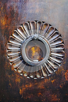 Old ancient door knocker on wooden door