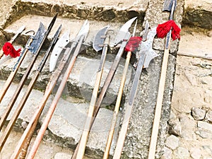 The old ancient medieval cold weapons, axes, halberds, knives, swords with wooden handles lick on the stone steps of the castle