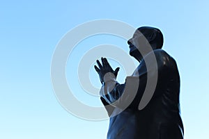 Praying metal statue and blue sky - Pray peace photo
