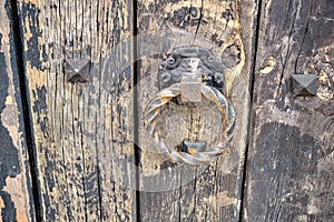 Old and ancient style door handle existing on big gate