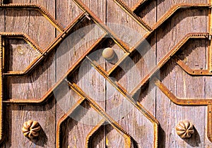 Old ancient wooden door with metal pattern background texture with lines and ridges