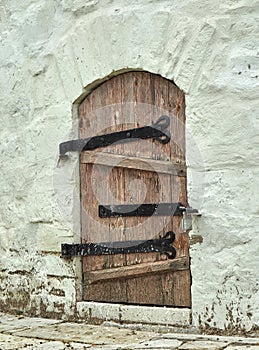 Ancient wooden door in stone castle wall