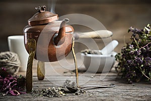 Old antique boiling teapot, mortar, dry coneflowers and thyme bunch