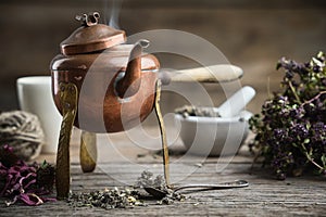 Old antique boiling teapot, mortar, dry coneflowers and thyme bunch photo