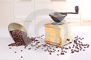 Old antique coffee grinder and a bowl with beans spilt
