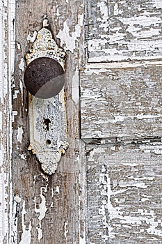 Old antique door knob and pealing white paint background